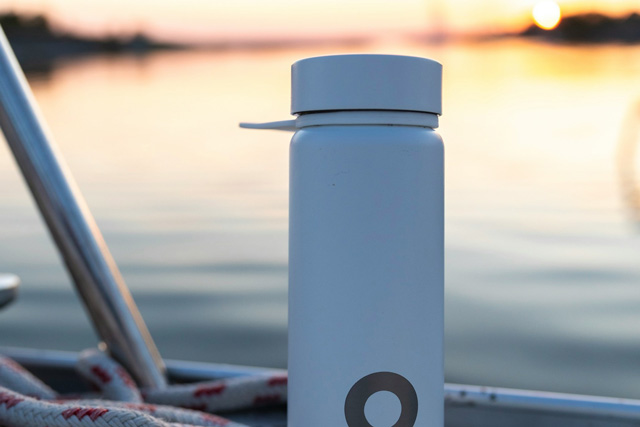 Eco-friendly water bottle sitting on the ledge of a boat.