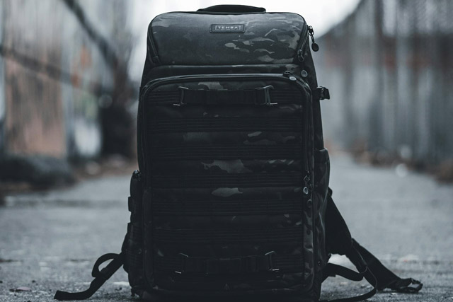 Black backpack sitting on a pier.